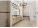 A luxurious bathroom with granite counters, double sinks, an oversized mirror, a chandelier, a tub, and a shower at 1665 Temple Dr, Winter Park, FL 32789