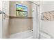 Bright bathroom featuring a white tub, tiled walls, a window view, and a shower curtain at 1665 Temple Dr, Winter Park, FL 32789