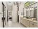 An elegant bathroom featuring double sinks, tile floors, and a large mirror with decorative lighting at 1665 Temple Dr, Winter Park, FL 32789
