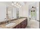 Elegant bathroom with a granite countertop vanity, dual sinks, and a doorway view to the Primary bedroom at 1665 Temple Dr, Winter Park, FL 32789