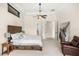 A spacious bedroom featuring a wooden bed frame, a seating area, and soft, neutral-toned decor at 1665 Temple Dr, Winter Park, FL 32789