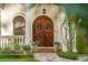 Inviting front entrance features double wood doors, fresh flowerpots, and colorful landscaping at 1665 Temple Dr, Winter Park, FL 32789
