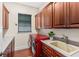 Laundry room with red washer and dryer, sink, and wooden cabinets at 1665 Temple Dr, Winter Park, FL 32789