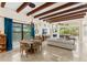 Bright living room with wood beam ceilings, a fireplace, large windows and access to the lanai at 1665 Temple Dr, Winter Park, FL 32789