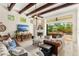 Spacious living room featuring a stone fireplace, wood-beamed ceilings, and sliding doors to the outdoor lanai at 1665 Temple Dr, Winter Park, FL 32789