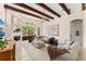 The living room features wood beam ceilings, a stone fireplace, and large glass doors opening to the lanai at 1665 Temple Dr, Winter Park, FL 32789