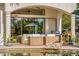 An outdoor patio with cozy wicker furniture, a barbecue grill, and a serene view of the pool area at 1665 Temple Dr, Winter Park, FL 32789