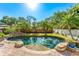 Freeform pool with stone accents and lush tropical landscaping offering a private backyard oasis at 1665 Temple Dr, Winter Park, FL 32789