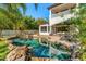 The backyard features a freeform pool, patio with furniture, and mature landscaping for the ultimate privacy at 1665 Temple Dr, Winter Park, FL 32789