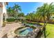 The backyard features a stunning freeform pool and spa, a lush garden, and a relaxing patio area at 1665 Temple Dr, Winter Park, FL 32789