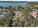 Aerial view showcasing the property, a lake, and surrounding neighborhood with lush trees at 16812 Vinci Way, Bella Collina, FL 34756