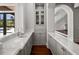 Butler's pantry featuring marble countertops, sink, and custom cabinetry with glass doors at 16812 Vinci Way, Bella Collina, FL 34756