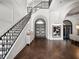 Elegant foyer featuring a grand staircase, dark wood floors, arched doorway, and stylish decor at 16812 Vinci Way, Bella Collina, FL 34756