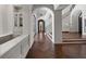 Spacious hallway with herringbone wood floors, arched doorways, and custom built-in cabinets at 16812 Vinci Way, Bella Collina, FL 34756