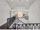 Upper landing showcasing railing and a view of a dazzling chandelier at 16812 Vinci Way, Bella Collina, FL 34756