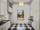 Bright laundry room featuring black and white floors, custom cabinetry, and ample counter space for folding at 16812 Vinci Way, Bella Collina, FL 34756