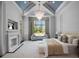 Inviting main bedroom featuring a cozy fireplace, sitting area, and a large window offering natural light at 16812 Vinci Way, Bella Collina, FL 34756