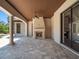 Spacious outdoor living area featuring a stone fireplace, travertine floors, wood-paneled ceiling, and large sliding glass doors at 16812 Vinci Way, Bella Collina, FL 34756