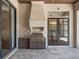 Outdoor kitchen with built-in BBQ, custom cabinetry, stone countertop, and views to dining room at 16812 Vinci Way, Bella Collina, FL 34756