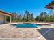 Beautiful geometric pool surrounded by travertine, landscaping and overlooking a wooded backyard at 16812 Vinci Way, Bella Collina, FL 34756
