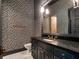 Chic powder room with dark vanity, elegant mirror, and patterned wallpaper adding a touch of sophistication at 16812 Vinci Way, Bella Collina, FL 34756