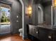Stylish powder room featuring dark wainscoting, modern fixtures, and a decorative mirror at 16812 Vinci Way, Bella Collina, FL 34756