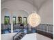 Elegant staircase featuring dark wood steps, decorative black iron railing, and an opulent crystal chandelier at 16812 Vinci Way, Bella Collina, FL 34756