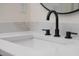A close-up of a modern bathroom sink with black faucet and white countertop featuring elegant design at 1686 17Th St, Orange City, FL 32763