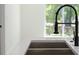 Close up of stainless steel kitchen sink with a spring coil faucet against white countertop and walls at 1686 17Th St, Orange City, FL 32763