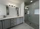 Bathroom featuring double sinks, a walk-in shower, and updated lighting at 1831 Abbots Hill Dr, Orlando, FL 32835
