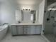 Updated bathroom featuring double sinks, a soaking tub, and a walk-in shower at 1831 Abbots Hill Dr, Orlando, FL 32835
