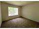 Inviting bedroom with plush carpeting, a window offering views, and neutral paint at 1831 Abbots Hill Dr, Orlando, FL 32835