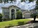 Two-story home featuring a well-maintained lawn and neutral color palette at 1831 Abbots Hill Dr, Orlando, FL 32835