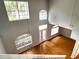 View from the top of the stairs down into the expansive foyer with hardwood floors and large windows at 1831 Abbots Hill Dr, Orlando, FL 32835
