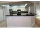 Kitchen with breakfast bar featuring modern appliances, white cabinets, and stone countertops at 1831 Abbots Hill Dr, Orlando, FL 32835