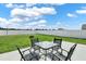 Spacious backyard featuring a patio with seating, green grass, and a tall privacy fence at 1963 Thompson Preserve Blvd, Bartow, FL 33830