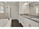 Bright bathroom featuring double sinks with granite counters, white cabinets, a soaking tub, and a separate glass shower at 1963 Thompson Preserve Blvd, Bartow, FL 33830