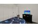 This is a secondary bedroom featuring a closet, white walls, dark wood floors, and a wall-mounted television at 1963 Thompson Preserve Blvd, Bartow, FL 33830