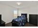 This is a minimalist bedroom with a window, a dark-wood floor, and a ceiling fan at 1963 Thompson Preserve Blvd, Bartow, FL 33830