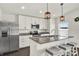 Modern kitchen with stainless steel appliances, gray granite countertops, a kitchen island and pendant lighting at 1963 Thompson Preserve Blvd, Bartow, FL 33830
