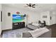 Cozy living room featuring dark wood floors, a ceiling fan, and an entertainment center with mounted television at 1963 Thompson Preserve Blvd, Bartow, FL 33830