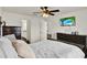 This is a main bedroom showcasing white walls, dark wood floors, and a ceiling fan, with a glimpse into the ensuite bathroom at 1963 Thompson Preserve Blvd, Bartow, FL 33830