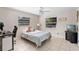 Neutral bedroom with tile floors and a queen bed next to desk and TV at 2132 Rouse Lake Rd, Orlando, FL 32817