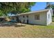 The backyard has mature trees providing shade and equipment stored along the back wall of the home at 2132 Rouse Lake Rd, Orlando, FL 32817