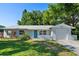 Charming single-story home with a blue front door, lush landscaping and an attached garage at 2132 Rouse Lake Rd, Orlando, FL 32817
