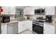 A well-lit kitchen features granite countertops, stainless steel appliances, and white cabinetry at 2132 Rouse Lake Rd, Orlando, FL 32817