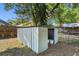 Metal shed with open door in a well-maintained backyard surrounded by fences and trees at 2132 Rouse Lake Rd, Orlando, FL 32817