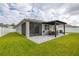 Well-manicured backyard with a screened-in patio, pergola-covered dining area, and beautiful landscaping at 236 Pink Ibis Bnd, St Cloud, FL 34772