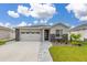 Attractive one-story house featuring a two-car garage, stone details, and meticulously maintained landscaping at 236 Pink Ibis Bnd, St Cloud, FL 34772