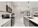 Bright kitchen features stainless steel appliances, grey cabinets, and quartz countertops at 236 Pink Ibis Bnd, St Cloud, FL 34772